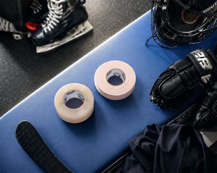 Hockey gear and USA Hockey Tape rolls on the bench